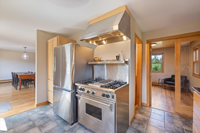14766 Danson Rd, Splithand Twp, MN 55744 - kitchen featuring appliances with stainless steel finishes, wall chimney range hood, wood finished floors, and a baseboard heating unit