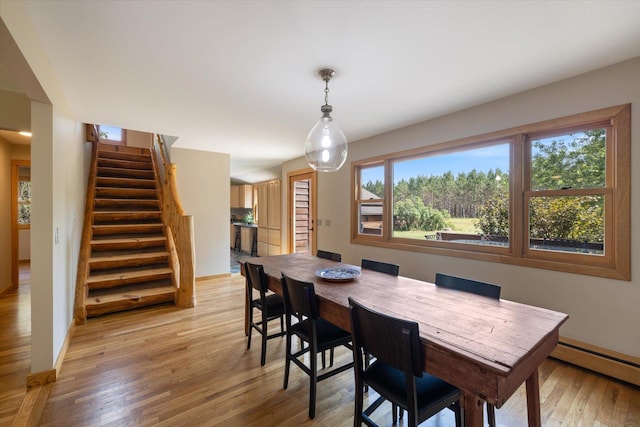 14766 Danson Rd, Splithand Twp, MN 55744 - dining area with a baseboard heating unit, stairway, and light wood-style flooring