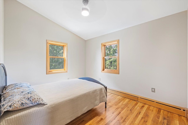 14766 Danson Rd, Splithand Twp, MN 55744 - bedroom featuring vaulted ceiling, a baseboard heating unit, wood finished floors, and a ceiling fan