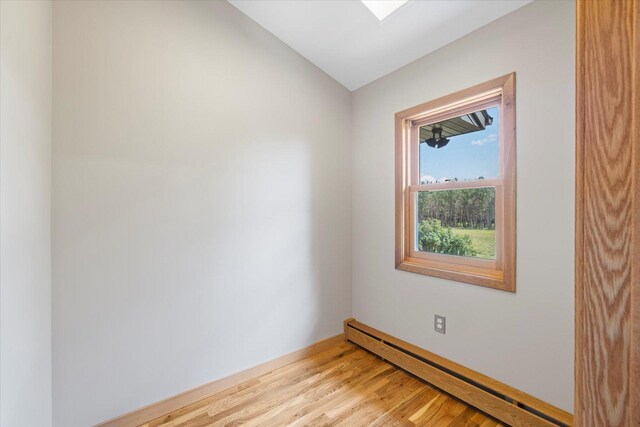 14766 Danson Rd, Splithand Twp, MN 55744 - spare room featuring a baseboard radiator, wood finished floors, and vaulted ceiling