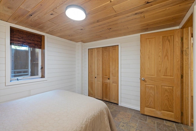 14766 Danson Rd, Splithand Twp, MN 55744 - bedroom featuring wooden ceiling, stone tile flooring, wood walls, and a closet