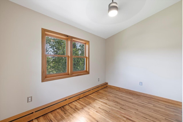 14766 Danson Rd, Splithand Twp, MN 55744 - empty room with a baseboard heating unit, light wood-style floors, and vaulted ceiling