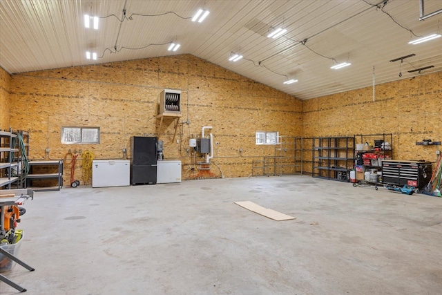 14766 Danson Rd, Splithand Twp, MN 55744 - garage featuring freestanding refrigerator, a workshop area, and fridge