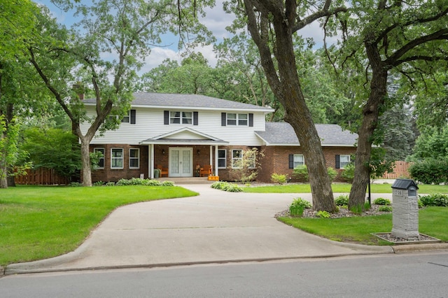1708 Woodland Rd, Saint Cloud, MN 56304 - view of front of house featuring french doors, brick siding, curved driveway, and roof with shingles