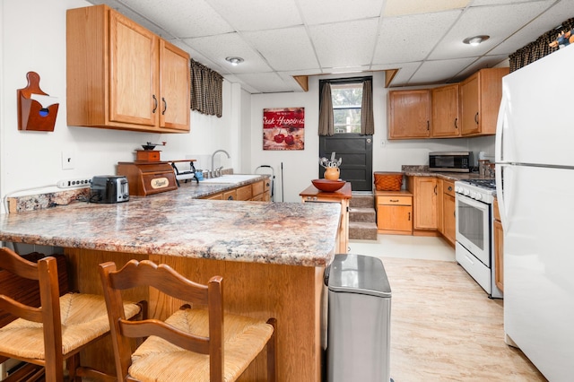 1708 Woodland Rd, Saint Cloud, MN 56304 - kitchen featuring white appliances, a peninsula, a breakfast bar area, and a drop ceiling