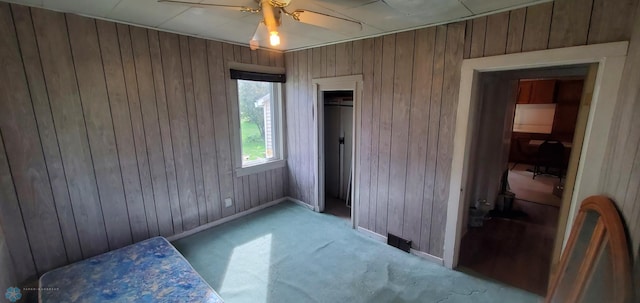 103 Main St S, Kindred, ND 58052 - unfurnished bedroom with wooden walls, light carpet, and a ceiling fan