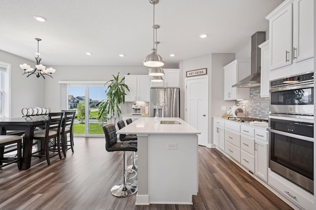 14660 109th Ave N, Maple Grove, MN 55369 - kitchen featuring appliances with stainless steel finishes, decorative backsplash, wall chimney exhaust hood, light countertops, and dark wood-style floors