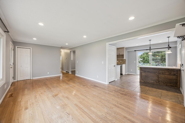 12209 Davenport St NE, Blaine, MN 55449 - unfurnished living room featuring light wood-style flooring, recessed lighting, and crown molding