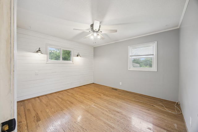 12209 Davenport St NE, Blaine, MN 55449 - unfurnished room with wood finished floors, a ceiling fan, wooden walls, and crown molding