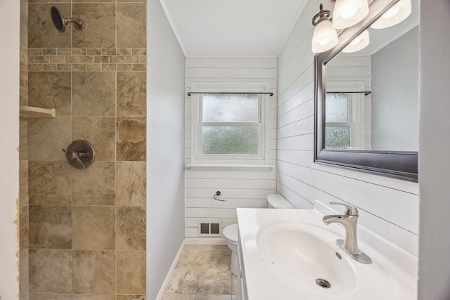 12209 Davenport St NE, Blaine, MN 55449 - bathroom with a tile shower, wooden walls, crown molding, and vanity