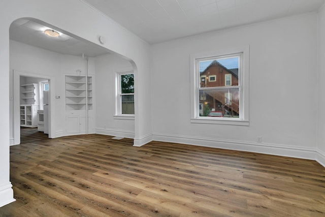 12 16th Ave N, Saint Cloud, MN 56303 - spare room with arched walkways, wood finished floors, and crown molding