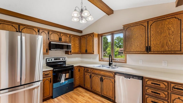 337 9 1/2 St N, Sauk Rapids, MN 56379 - kitchen with stainless steel appliances, brown cabinetry, a chandelier, light countertops, and light wood-type flooring