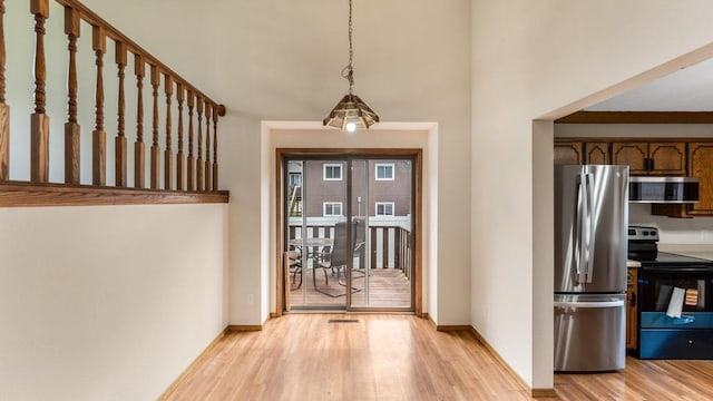 337 9 1/2 St N, Sauk Rapids, MN 56379 - kitchen with appliances with stainless steel finishes, light wood-style flooring, a towering ceiling, and pendant lighting
