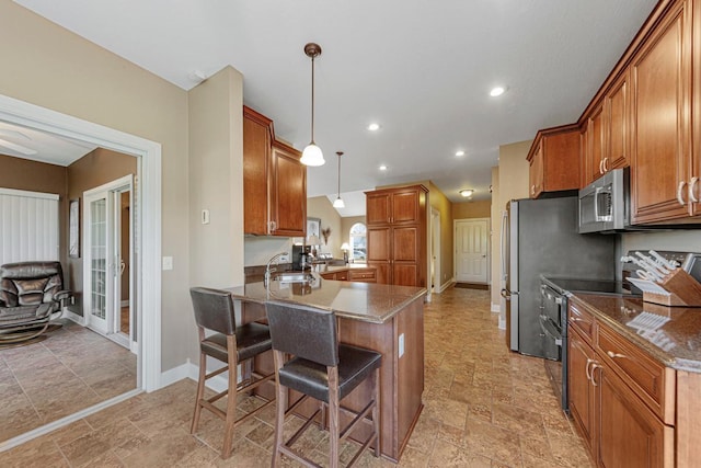 1904 Rock Ridge Ln, Saint Peter, MN 56082 - kitchen featuring stainless steel appliances, stone finish flooring, brown cabinets, a breakfast bar, and recessed lighting