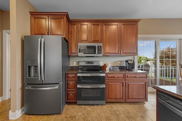 1904 Rock Ridge Ln, Saint Peter, MN 56082 - kitchen featuring appliances with stainless steel finishes, brown cabinetry, and dark countertops