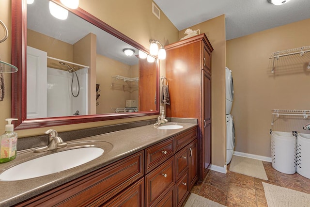 1904 Rock Ridge Ln, Saint Peter, MN 56082 - full bath featuring stacked washer / dryer, double vanity, a walk in closet, a shower, and stone finish flooring