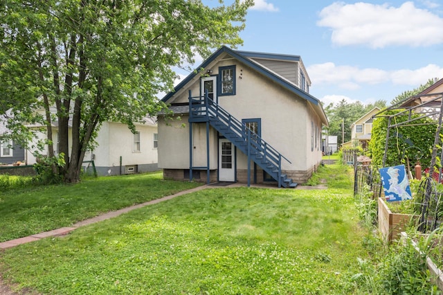 3809 41st Ave S, Minneapolis, MN 55406 - back of property featuring stairs, stucco siding, a vegetable garden, and a yard