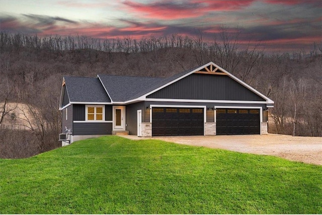 S1546 Shawnee Dr Unit B, Alma, WI 54610 - view of front of home featuring dirt driveway, a yard, a garage, and a shingled roof