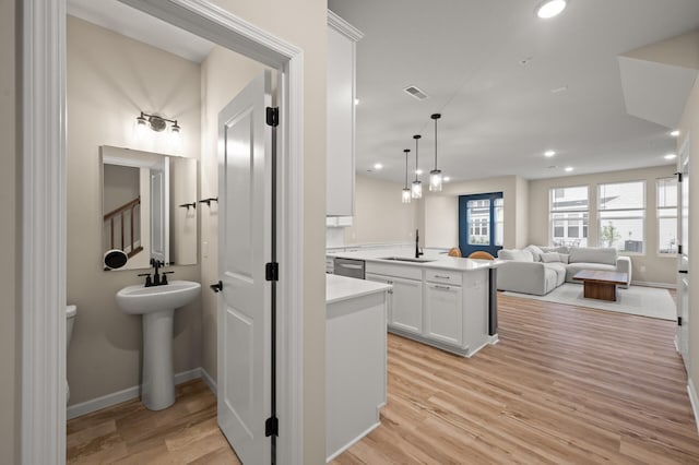 2570 Paddock Path, Shakopee, MN 55379 - kitchen featuring open floor plan, white cabinets, light countertops, light wood-type flooring, and decorative light fixtures