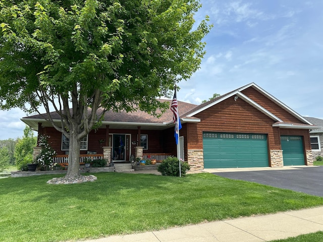 3110 8th Ave NW, Faribault, MN 55021 - view of front of property featuring a garage, asphalt driveway, stone siding, a front yard, and a porch