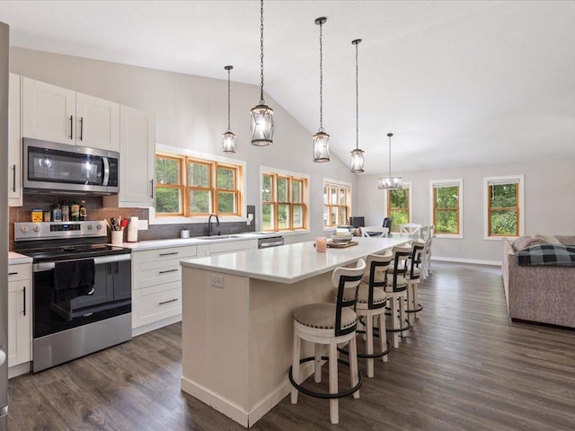 6629 45th Ave SW, Moose Lake Twp, MN 56472 - kitchen featuring stainless steel appliances, light countertops, decorative backsplash, white cabinets, and open floor plan