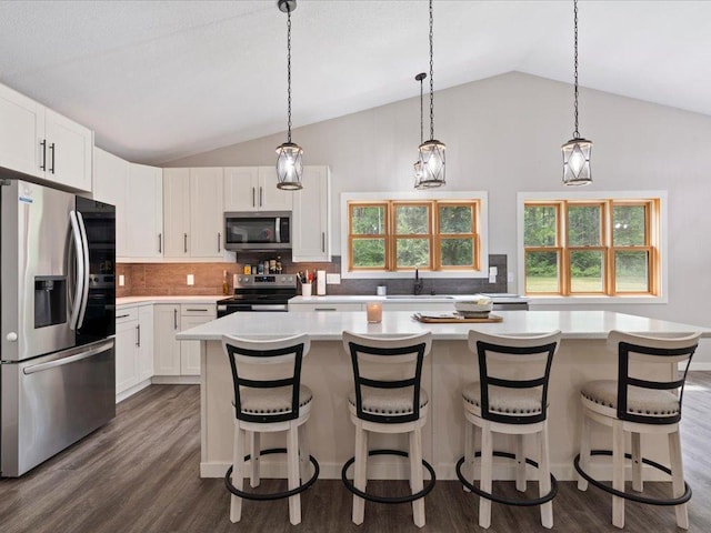 6629 45th Ave SW, Moose Lake Twp, MN 56472 - kitchen with appliances with stainless steel finishes, lofted ceiling, light countertops, white cabinetry, and tasteful backsplash