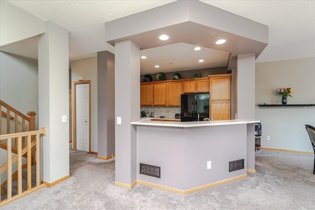 4363 Victor Path Unit 7, Hugo, MN 55038 - kitchen featuring freestanding refrigerator, light carpet, decorative backsplash, brown cabinets, and light countertops
