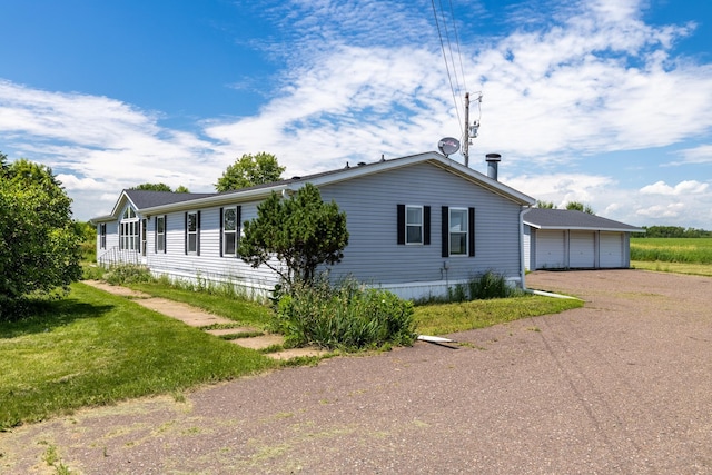 6257 State Highway 70, Rock Creek, MN 55063 - view of property exterior featuring a garage, driveway, an outbuilding, and a lawn