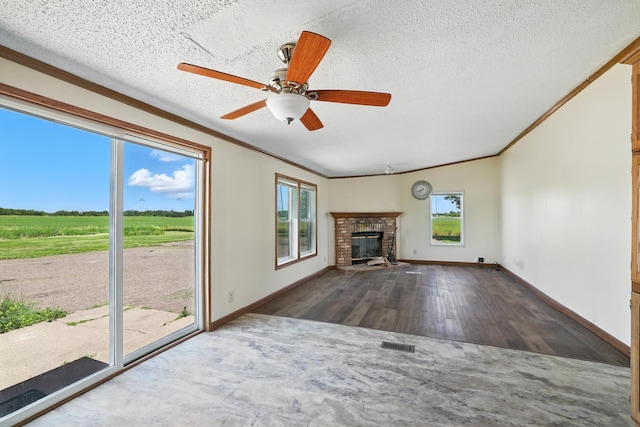 6257 State Highway 70, Rock Creek, MN 55063 - unfurnished living room featuring plenty of natural light, crown molding, wood finished floors, a fireplace, and ceiling fan