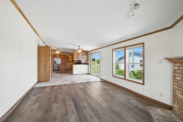 6257 State Highway 70, Rock Creek, MN 55063 - unfurnished living room with crown molding, wood finished floors, a textured ceiling, and ceiling fan