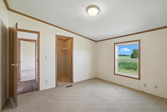 6257 State Highway 70, Rock Creek, MN 55063 - unfurnished bedroom with light carpet, a textured ceiling, vaulted ceiling, crown molding, and a walk in closet