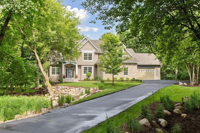 3027 135th Ave NE, Ham Lake, MN 55304 - view of front of house featuring stone siding, a front yard, and asphalt driveway