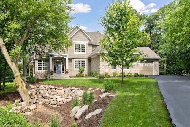 3027 135th Ave NE, Ham Lake, MN 55304 - view of front of home with stone siding, asphalt driveway, a front lawn, and an attached garage
