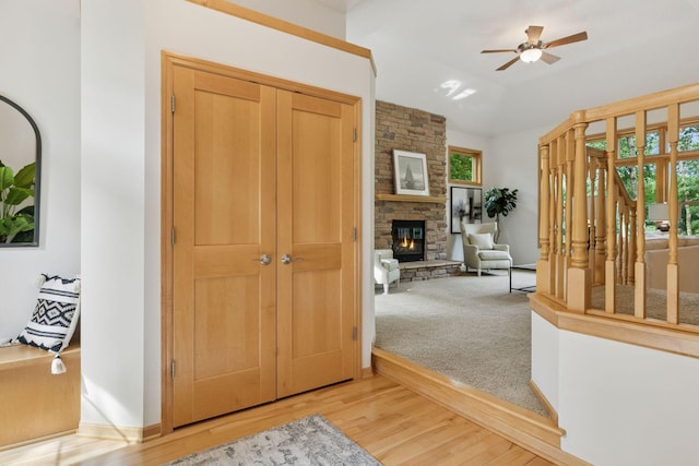 3027 135th Ave NE, Ham Lake, MN 55304 - foyer entrance with healthy amount of natural light, a stone fireplace, a ceiling fan, wood finished floors, and vaulted ceiling