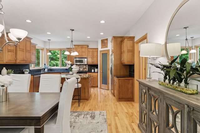 3027 135th Ave NE, Ham Lake, MN 55304 - kitchen with stainless steel appliances, a kitchen island, light wood-style flooring, tasteful backsplash, and recessed lighting