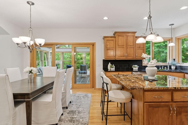 3027 135th Ave NE, Ham Lake, MN 55304 - kitchen featuring a chandelier, brown cabinetry, light wood-style flooring, decorative backsplash, and recessed lighting