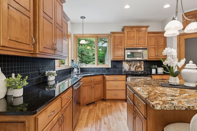 3027 135th Ave NE, Ham Lake, MN 55304 - kitchen with stainless steel appliances, brown cabinetry, light wood finished floors, pendant lighting, and recessed lighting