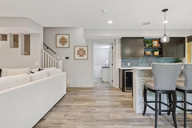 3027 135th Ave NE, Ham Lake, MN 55304 - indoor wet bar featuring beverage cooler, light wood-style floors, stairs, backsplash, and hanging light fixtures