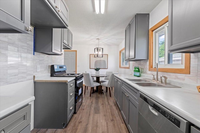5738 Yates Ave N, Crystal, MN 55429 - kitchen with stainless steel appliances, gray cabinetry, decorative backsplash, wood finished floors, and a textured ceiling