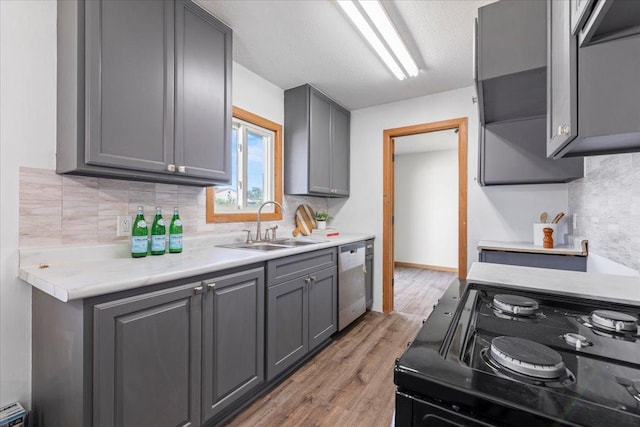 5738 Yates Ave N, Crystal, MN 55429 - kitchen featuring stainless steel dishwasher, black range oven, gray cabinets, light wood finished floors, and tasteful backsplash