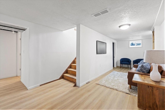 5738 Yates Ave N, Crystal, MN 55429 - sitting room with light wood-style flooring, a textured ceiling, and stairway
