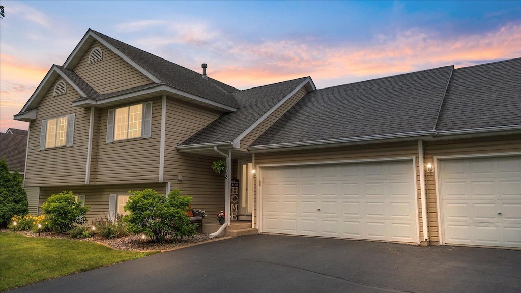 708 12th St, Farmington, MN 55024 - view of front facade with asphalt driveway, an attached garage, and roof with shingles