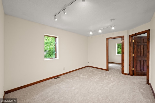 2117 Oakridge St, Saint Paul, MN 55119 - carpeted empty room featuring plenty of natural light, track lighting, and a textured ceiling