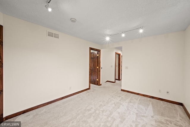 2117 Oakridge St, Saint Paul, MN 55119 - spare room featuring rail lighting, light colored carpet, and a textured ceiling