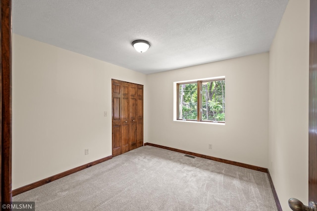 2117 Oakridge St, Saint Paul, MN 55119 - unfurnished bedroom with carpet, a closet, and a textured ceiling