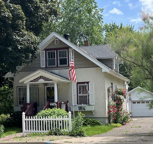 2714 17th Ave E, North Saint Paul, MN 55109 - view of front of home featuring an outdoor structure, a chimney, stucco siding, a garage, and driveway