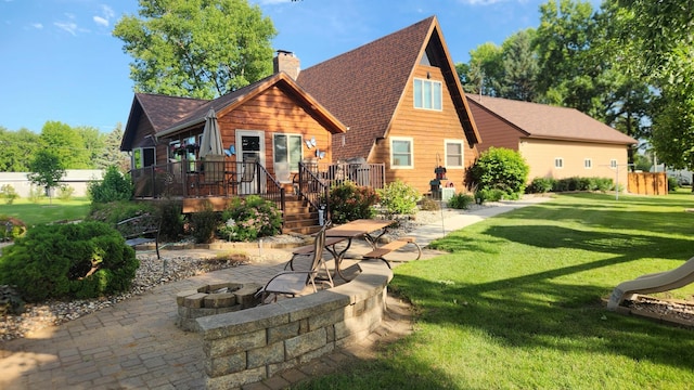 511 4th St W, Jasper, MN 56144 - back of house with an outdoor fire pit, a deck, a yard, a shingled roof, and a chimney