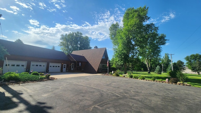 511 4th St W, Jasper, MN 56144 - view of front of house featuring driveway, a garage, and a chimney