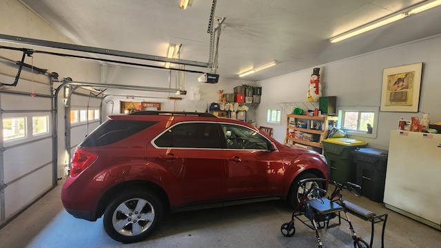 511 4th St W, Jasper, MN 56144 - garage with freestanding refrigerator and a garage door opener