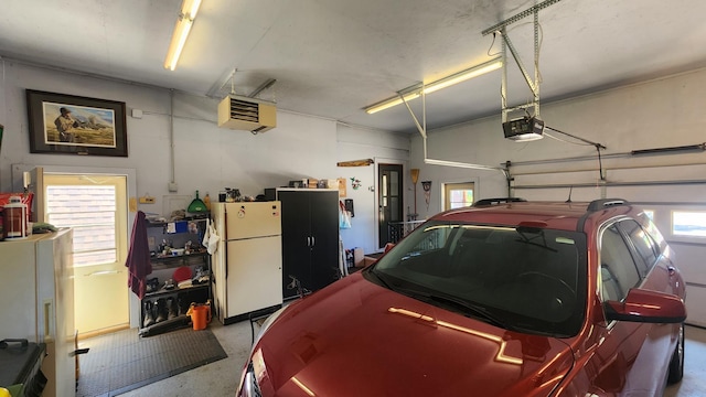 511 4th St W, Jasper, MN 56144 - garage with freestanding refrigerator, a heating unit, and a garage door opener